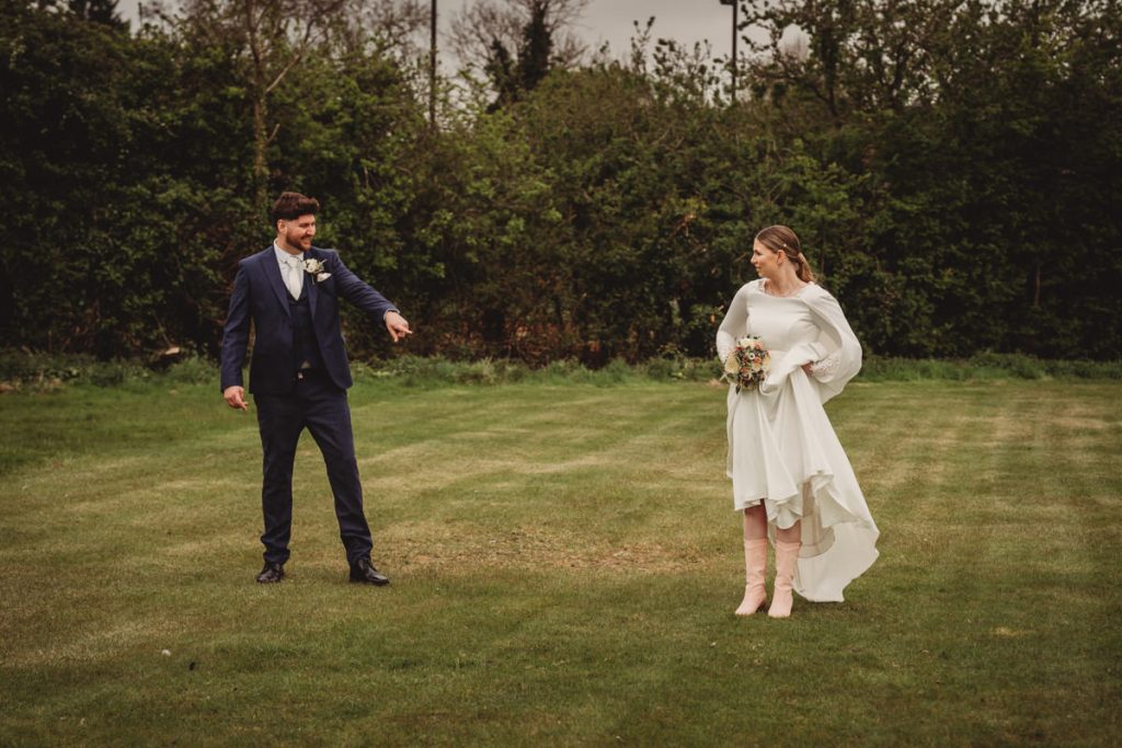 Bride and groom standing on a grassy field