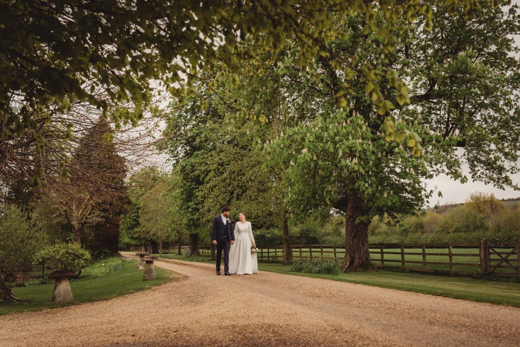 Couple walking on path through lush garden.