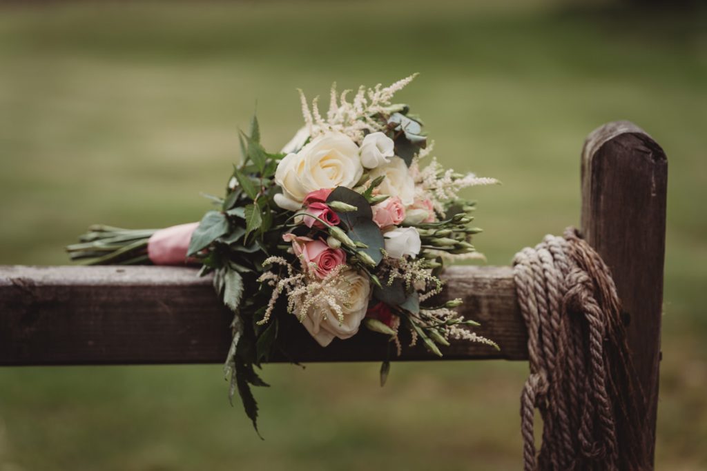 Rustic bouquet on wooden fence outdoors