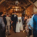 Bride and groom walking down wedding aisle.