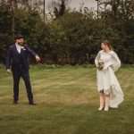 Bride and groom laughing in a garden setting.