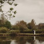 Wedding couple by a serene lake.