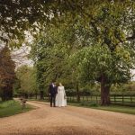 Couple walking on country path among trees.