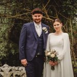 Bride and groom in garden wedding scene.