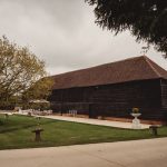 Large wooden barn with garden and trees