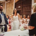 Bride and groom laughing during wedding ceremony.