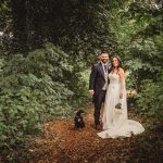 Bride and groom in forest with dog.