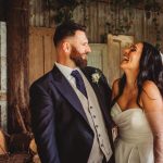 Bride and groom laughing joyfully on wedding day.