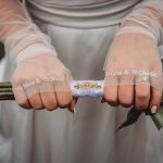 Bride holding bouquet with embroidered gloves