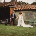 Bride and groom with dog by old garage