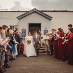 Wedding couple exiting ceremony, guests throwing confetti.