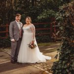 Bride and groom smiling outdoors during wedding.