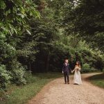 Bride and groom walking in forest path