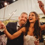 Couple celebrating with sparklers at a party.