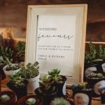 Wedding favours sign with potted succulents display.