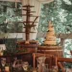 Rustic wedding cake setup in forest-themed setting.