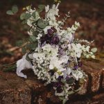 Rustic floral bouquet on weathered brick wall outdoors.