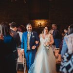 Bride and groom walking down the aisle, smiling.