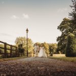 Bride and groom walking down country lane.