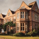 Elegant manor with couple outside during sunset.