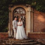 Bride and groom outside historic brick building.