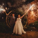 Newlyweds celebrating with sparklers at night.