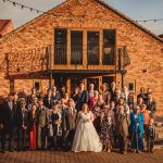 Wedding group photo at rustic brick venue.