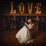 Bride and groom dancing under 'LOVE' sign