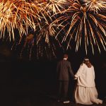 Couple watching fireworks display at night.