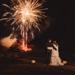 Couple watching fireworks in the night sky.