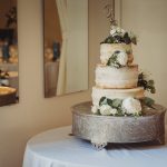 Three-tier wedding cake with floral decorations.