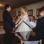 Couple exchanging vows at indoor wedding ceremony.