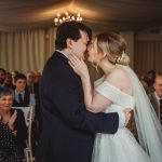 Bride and groom kissing at wedding ceremony.