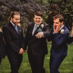 Groomsmen react to groom showing wedding ring.