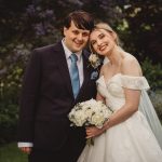 Smiling couple on wedding day in garden.