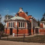 Historic brick building with green dome and columns.