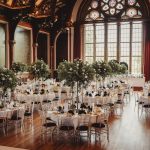 Elegant wedding venue with floral centrepieces and chandeliers.