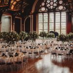 Elegant banquet hall with round tables and flowers.