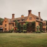 Historic manor house with ivy-covered walls and garden.