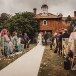 Outdoor wedding ceremony with guests seated.