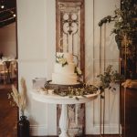 Elegant wedding cake with floral decorations on table.