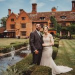 Couple wedding photo outside historic brick building garden.