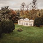 Orangery surrounded by autumnal trees in English garden.