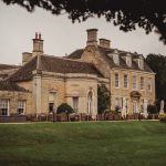 Historic stone manor house with landscaped garden.