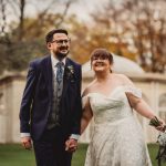 Happy couple holding hands at wedding ceremony.