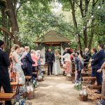 Outdoor wedding ceremony with guests applauding newlyweds.