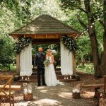 Outdoor wedding ceremony at woodland venue with couple.