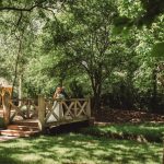 Bride and groom on bridge in lush garden