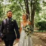 Couple in wedding attire walking in forest