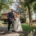 Bride and groom walking in garden path.